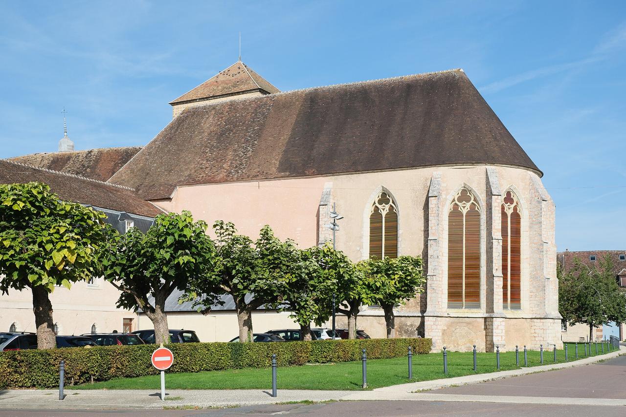 Église Saint-Ayoul de Provins, façade extérieure avec toit en chaume et vitraux gothiques.